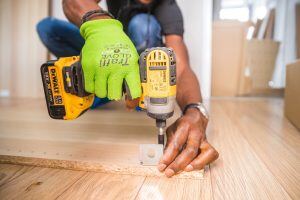 person-using-dewalt-cordless-impact-driver-on-brown-board-1249611-300x200