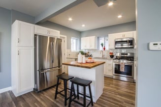 two-black-wooden-bar-stools-near-table-and-french-door-1663263-768x512