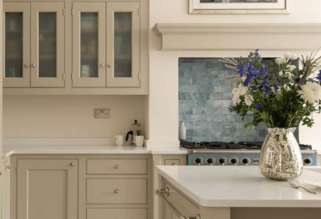 A kitchen with soft grey cabinets, a white countertop, and a blue tiled backsplash, demonstrating how a Georgian kitchen can look fresh and timeless for decades.