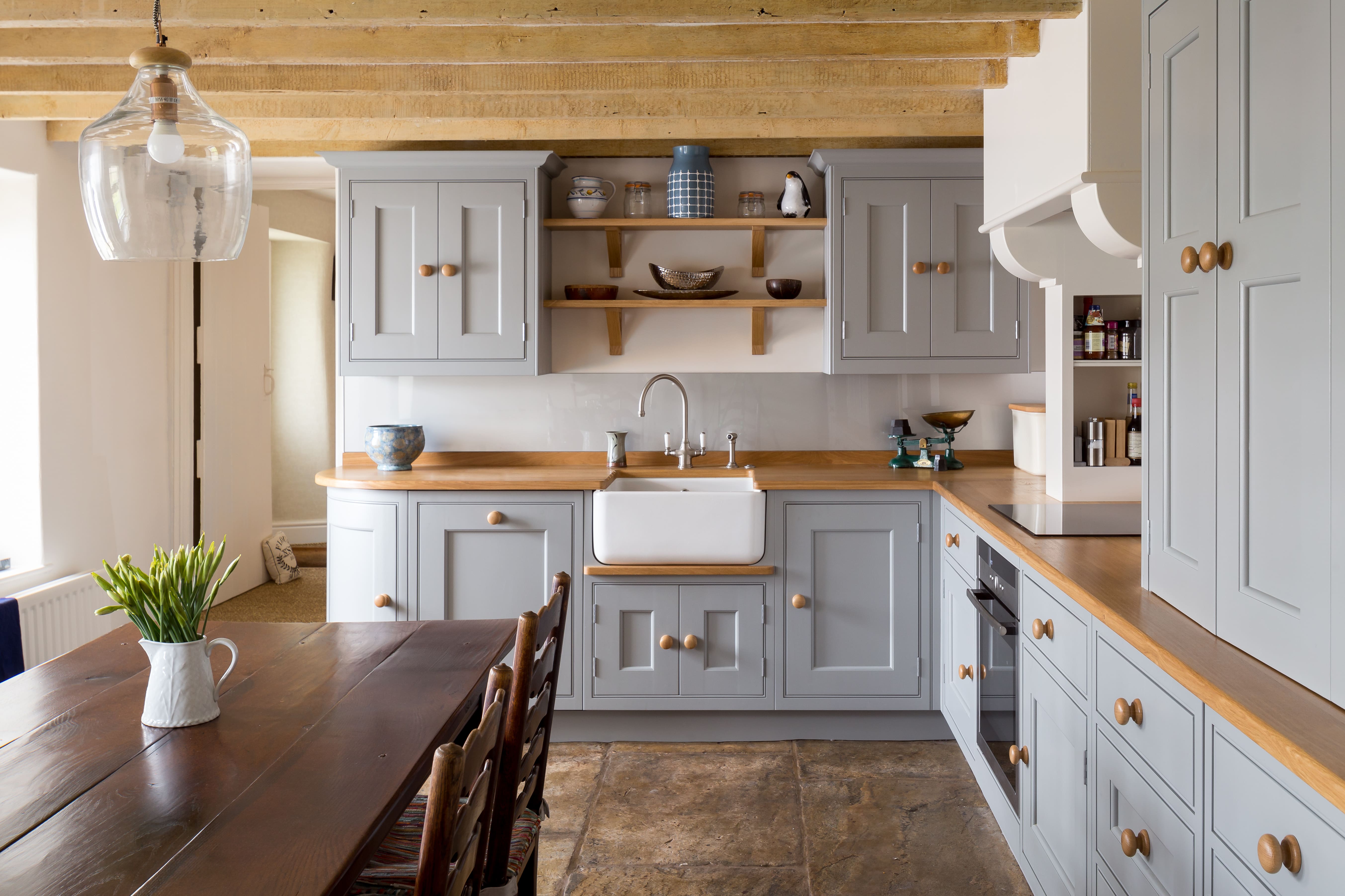 A Shaker-style kitchen exudes luxurious minimalism with clean lines and understated grey cabinetry reflecting the essence of a minimalist aesthetic with functionality and quality.