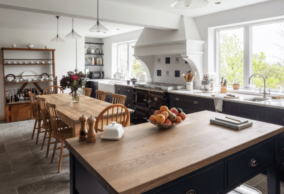 A spacious, rustic kitchen with wooden cabinetry, a large island, and a dining table, showing the warm and inviting appeal of natural wood in kitchen design. 